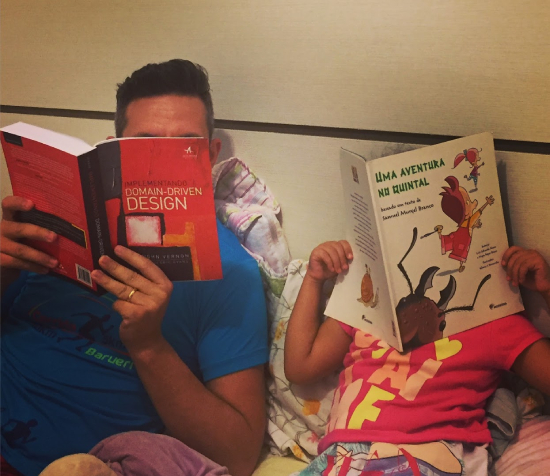 My daughter and me reading side by side before bed, she with a children's book and me with the red DDD book