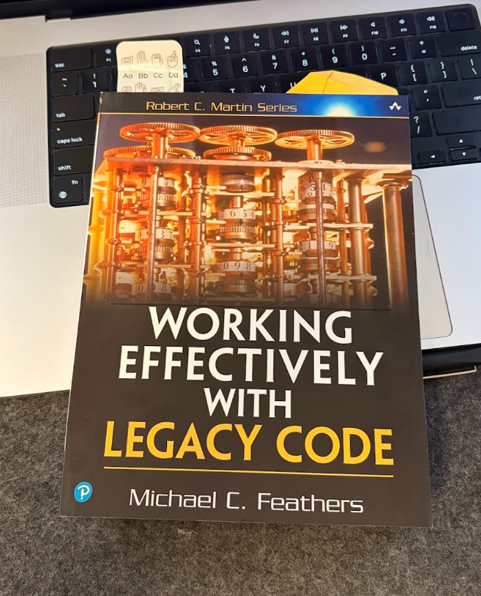 The book Working Effectively with Legacy Code by Michael Feathers, resting on a laptop keyboard
